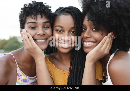 Lächelnde junge Freundinnen mit Wange zu Wange Stockfoto