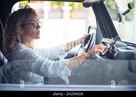 Reife Frau, die eine Brille trägt und ein globales Positionierungssystem auf dem Smartphone verwendet, während sie im Auto sitzt Stockfoto