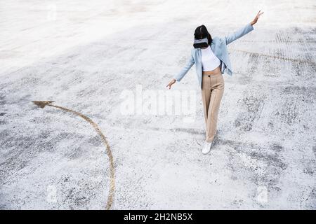 Teenager-Mädchen mit Virtual-Reality-Headset auf Parkplatz Garage Dach Stockfoto