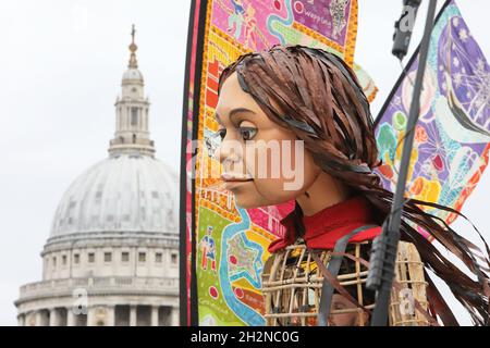 London, Großbritannien, 23. Oktober 2021. Die kleine Amal, eine riesige Marionette eines jungen syrischen Flüchtlings, hielt inne, um die Aussicht zu genießen, als sie von der St. Paul's Cathedral über die Millennium Bridge ging. Sie ist aus der Türkei gegangen und hat nach ihrer Mutter gesucht, um die Notlage junger Flüchtlinge auf der ganzen Welt hervorzuheben. Monica Wells/Alamy Live News Stockfoto