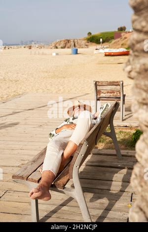 Mann, der sich an sonnigen Tagen auf der Bank entspannt Stockfoto