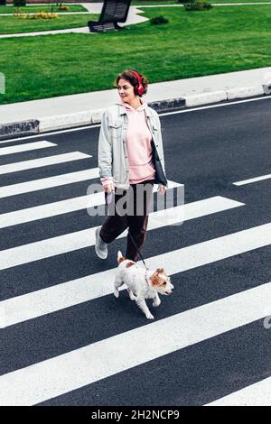 Lächelnde Frau mit Jack Russell Terrier über die Straße Stockfoto