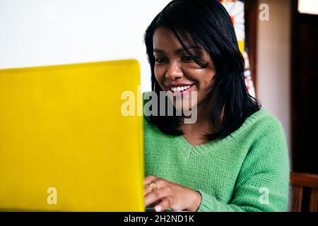 Lächelnde Freiberuflerin, die zu Hause am Laptop arbeitet Stockfoto