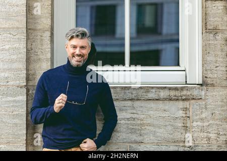 Bärtiger Mann, der inmitten von Säulen sitzt Stockfoto