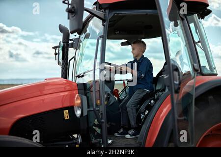 Junge fährt Traktor auf dem Bauernhof Stockfoto