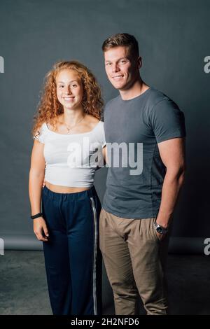 Lächelndes junges Paar, das im Studio zusammensteht Stockfoto