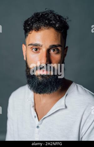 Junger Mann mit schwarzem Bart im Studio Stockfoto