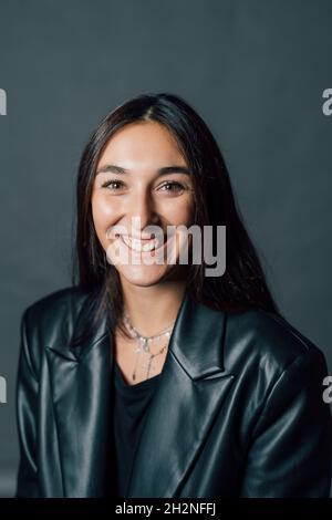 Glückliche junge Frau in schwarzer Lederjacke Stockfoto