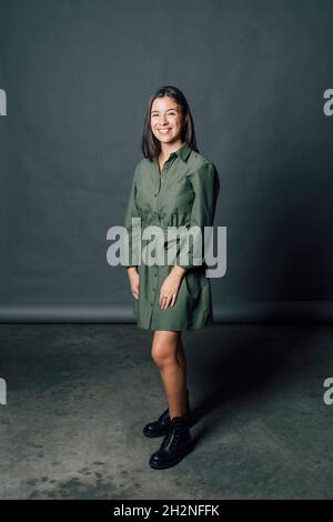 Lächelnde junge Frau, die im Studio steht Stockfoto