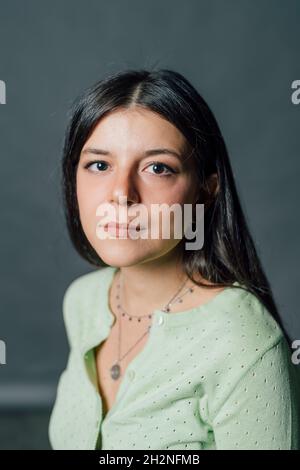 Junge Frau, die im Studio sitzt Stockfoto