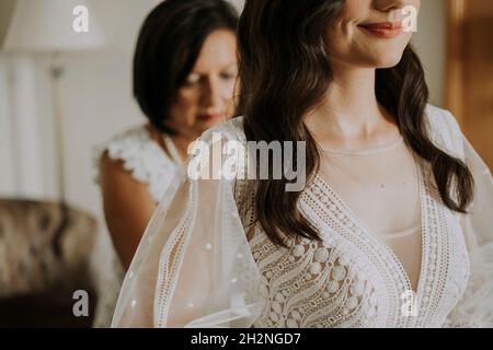Lächelnde Frau, die sich zu Hause auf die Hochzeit vorbereitet Stockfoto
