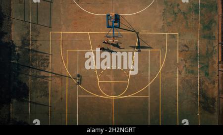 Männliche Freunde spielen Basketball auf dem Sportplatz Stockfoto