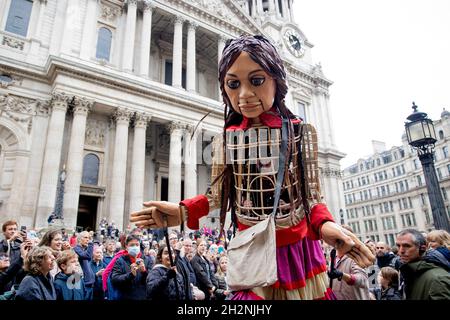 London, Großbritannien. Oktober 2021. Little Amal sah, wie sie vor der St Paul Cathedral durch die Menge von Anhängern ging.Little Amal, eine 3.5 Meter hohe Puppe, die als 9 Jahre altes syrisches Flüchtlingsmädchen dargestellt wurde und alle Flüchtlingskinder vertrat, traf am Großen Tor der St Paul Cathedral in der Londoner Innenstadt ein. Seit Juli dieses Jahres ist sie auf Reisen und verlässt die syrisch-türkische Grenze auf der Suche nach ihrer Mutter. Sie wird 8000 km laufen und Anfang November als Endziel in Manchester ankommen, wo sie auch den Standort der kurzfristigen Einrichtung für Flüchtlinge im Vereinigten Königreich bildet. Kredit Stockfoto