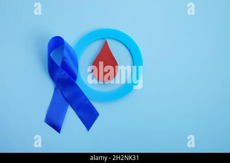 Bewusstsein für den Weltdiabetestag. Blaues Band und Kreis mit Blutstropfen. Stockfoto