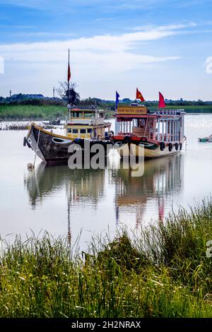 Zwei Boote, die in einem Kanal auf Cam Kim Island nebeneinander gebunden sind. Stockfoto