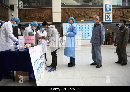 Lanzhou, Chinas Provinz Gansu. Oktober 2021. Am 23. Oktober 2021, im Provinzkrankenhaus für traditionelle Chinesische Medizin (TCM) in Lanzhou, nordwestlich der Provinz Gansu, stehen Menschen Schlange, um Abkokungen für COVID-19 Prävention und Kontrolle zu erhalten. Apotheker des Krankenhauses sind damit beschäftigt, Abkokungen zur COVID-19-Prävention und -Kontrolle für Personen unter ärztlicher Quarantäne und medizinisches Personal an der Front bereitzustellen. Das Krankenhaus bot die Abkokungen auch den Anwohnern kostenlos in der Ambulanz an. Quelle: Chen Bin/Xinhua/Alamy Live News Stockfoto