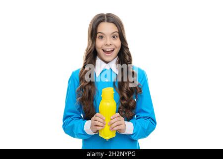 Happy Kid halten gelbe Plastikflasche mit flüssigen Milchprodukten isoliert auf weißem, trinkbarem Joghurt Stockfoto