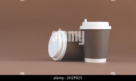 Banner von zwei gewellten Kaffeebechern aus Papier mit Kappen auf braunem Hintergrund mit Platz zum Kopieren Stockfoto
