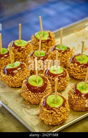 Frisch zubereitete Karamelläpfel mit grünen Äpfeln, Karamell und überzogen mit zerdrückter Erdnussauflage auf Tablett, Pigeon Forge, Tennessee, USA. Stockfoto