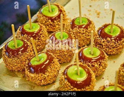 Frisch zubereitete Karamelläpfel mit grünen Äpfeln, Karamell und überzogen mit zerdrückter Erdnussauflage auf Tablett, Pigeon Forge, Tennessee, USA. Stockfoto