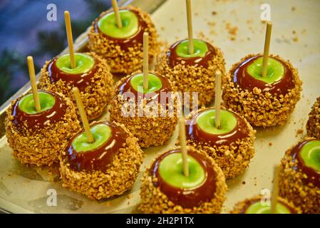 Frisch zubereitete Karamelläpfel mit grünen Äpfeln, Karamell und überzogen mit zerdrückter Erdnussauflage auf Tablett, Pigeon Forge, Tennessee, USA. Stockfoto