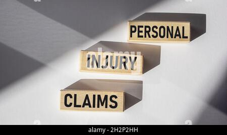 Text von Holzblöcken auf dem Schreibtisch für Verletzungsansprüche Stockfoto