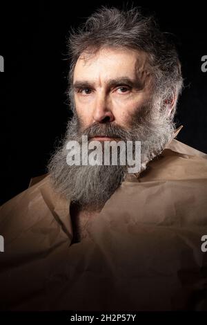 Ein lustiges Porträt eines älteren Mannes mit einem Renaissance-Bart, eingewickelt in Papier. Stockfoto