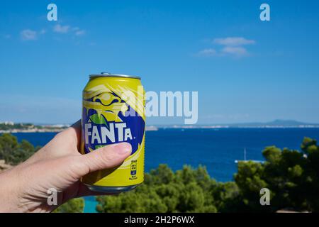 Spanische Fanta kann in einer Hand vor einer Meereslandschaft Stockfoto