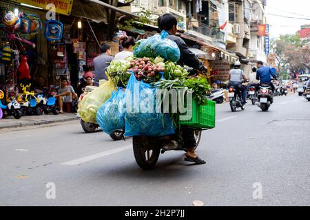 HANOI, VIETNAM - 19. Februar 2015: Ein Kurier liefert Gemüse auf einem Fahrrad in Hanoi, Vietnam Stockfoto