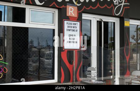 Schild am Eingang des Restaurants: „Bitte geben Sie nicht mit Symptomen von Covid19, Rassismus, Homophobie ein“ Stockfoto