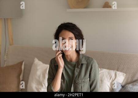 Fröhliche hispanische Frau mit Handy, das anruft Stockfoto