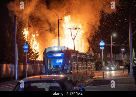 Straßenbahnen passieren ein großes Feuer auf dem Abfallplatz in Beeston Nottingham Stockfoto