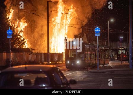 Straßenbahnen passieren ein großes Feuer auf dem Abfallplatz in Beeston Nottingham Stockfoto