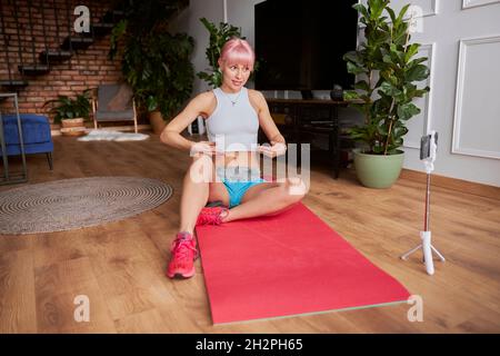Professioneller Trainer im Trainingsanzug macht Videos für Blogs zu Hause Stockfoto