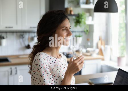 Glückliche freiberufliche Mitarbeiterin, die von zu Hause aus am Laptop arbeitet Stockfoto