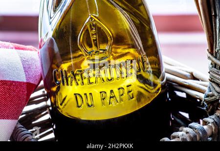 Chateauneuf-du-Pape Blick aus der Nähe auf Glasrelief Namensschild auf Flasche Chateauneuf-du-Pape Rotwein in rustikalem Weidenkorb Vaucluse Region Frankreich Stockfoto