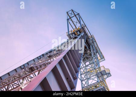 Grubenschachtturm 'Krystyn' in der ehemaligen Kohlemine 'Michal' in Siemianowice, Schlesien, Polen von unten gesehen gegen blauen Himmel mit rosa Wolken. Stockfoto