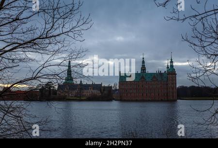 Schloss Frederiksborg am Abend, mit See und Baum im Vordergrund, Hillerod, Dänemark Stockfoto