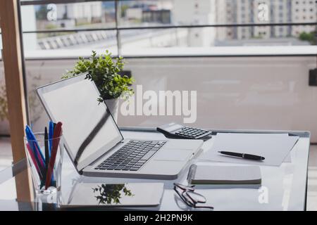 Büroarbeitsplatz, Arbeitsplatz mit Laptop-Computer auf Glastisch, Innenraum des Arbeitsplatzes Desktop Stockfoto