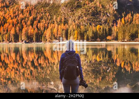 Reisen Sie im Herbst im Freien, Fotograf Reisende mit Rucksack und dslr-Kamera in der Nähe Bergsee stehen Stockfoto