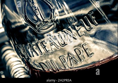 Chateauneuf-du-Pape Blick aus der Nähe auf Glasrelief Namensschild auf Flasche Chateauneuf-du-Pape Rotwein in rustikalem Weidenkorb Vaucluse Region Frankreich Stockfoto