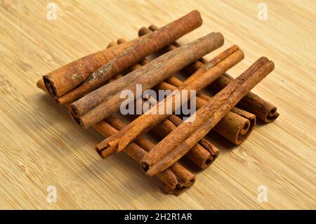 Getrocknete lange braune Zimtstangen, aromatische Würze, auf Holzboden Stockfoto