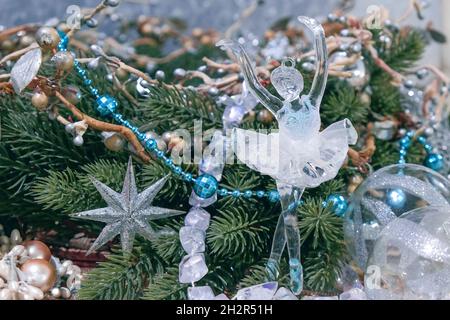 Vintage-Glasfigur der tanzenden Ballerina auf dem weihnachtsbaumkranz unter festlichen Dekorationen zum neuen Jahr. Magisches weihnachtsmärchen. Stockfoto
