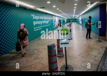 Kuala Lumpur, Malaysia. Oktober 2021. Menschen mit Gesichtsmasken als vorbeugende Maßnahme gegen die Ausbreitung des Coronavirus gehen durch einen unterirdischen Tunnel, der die Light Rail Transit (LRT)-Station mit dem KLCC in Kuala Lumpur verbindet. Malaysia befindet sich derzeit in der Erholungsphase von Covid-19, die Anfang Oktober mit der Aufrechterhaltung mehrerer Standard Operation Procedures (SOPs) begann, um die Ausbreitung der Covid-19-Infektion einzudämmen. Kredit: SOPA Images Limited/Alamy Live Nachrichten Stockfoto