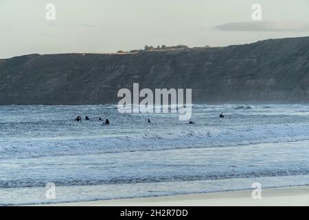 Scarborough, Großbritannien. Oktober 2021. Surfer paddeln vor Sonnenaufgang aus, um am Scarborough Beach in Yorkshire einige Wellen zu fangen. Kredit: SOPA Images Limited/Alamy Live Nachrichten Stockfoto