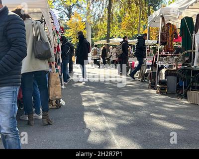 Flohmarkt in der Schweiz an einem sonnigen Samstag-Oktober-Nachmittag. Die Käufer schauen sich die Ware an den Ständen an. Der Kopierbereich befindet sich im Vordergrund. Stockfoto