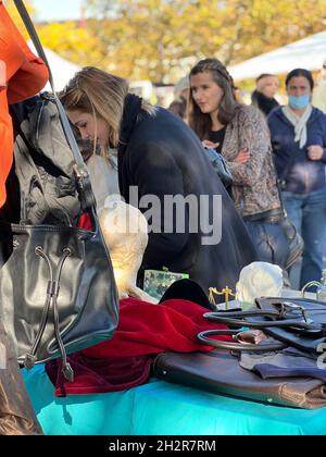 Die Kunden kontrollieren Waren am Flohmarktstand. Junge Frauen auf dem traditionellen Flohmarkt am Burkliplatz in Zürich. Stockfoto