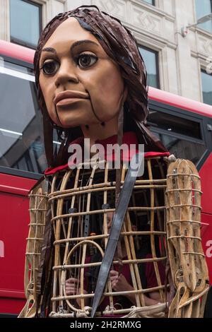 London, Großbritannien. Oktober 2021. Die kleine Amal, eine riesige Marionette eines syrischen Flüchtlingsmädchens, das vor Konflikten flüchtet, nähert sich der St. Paul's Cathedral. Die 3.5 Meter lange Marionette, die sich dem Ende einer 8.000 km langen Reise von der türkisch-syrischen Grenze nach Manchester zur Unterstützung von Flüchtlingen nähert, kletterte die Stufen der St. Paul's Cathedral hinauf, um dem Dekan eine Holzschnitzerei eines Schiffes auf See vom Geburtsort des St. Paul in Tarsus in der Türkei zu präsentieren. Kredit: Mark Kerrison/Alamy Live Nachrichten Stockfoto