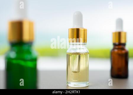 Set aus mehrfarbigen Glasflaschen mit Pipette auf dem Tisch. Konzept von Aromaöl, Kosmetik- und Schönheitshaut. Stockfoto