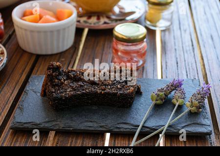 Kekskuchen aus nächster Nähe auf einem Schieferstein, neben Lavendelblüten. Stockfoto